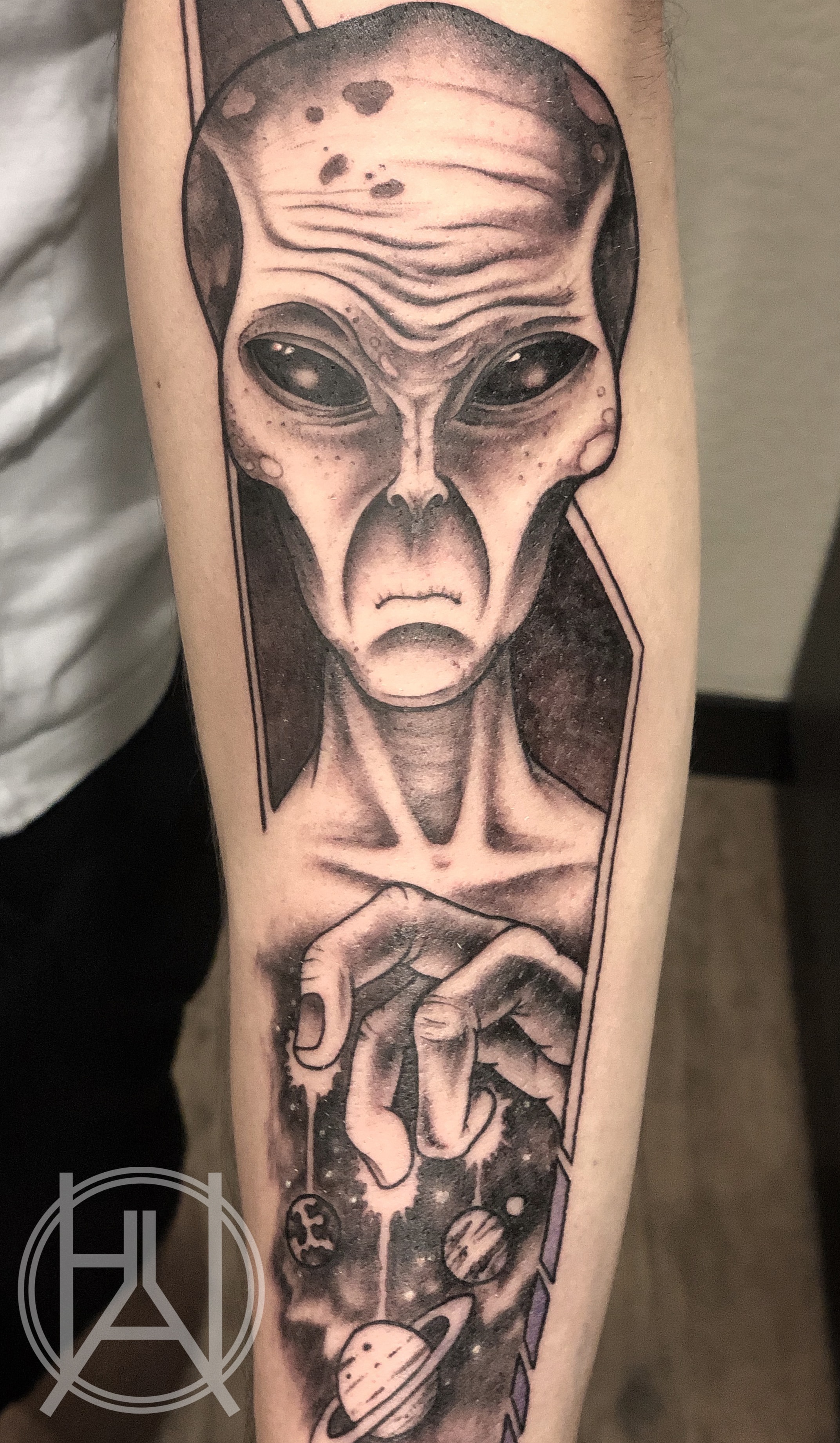Alien holding planets in space — black and grey forearm sleeve