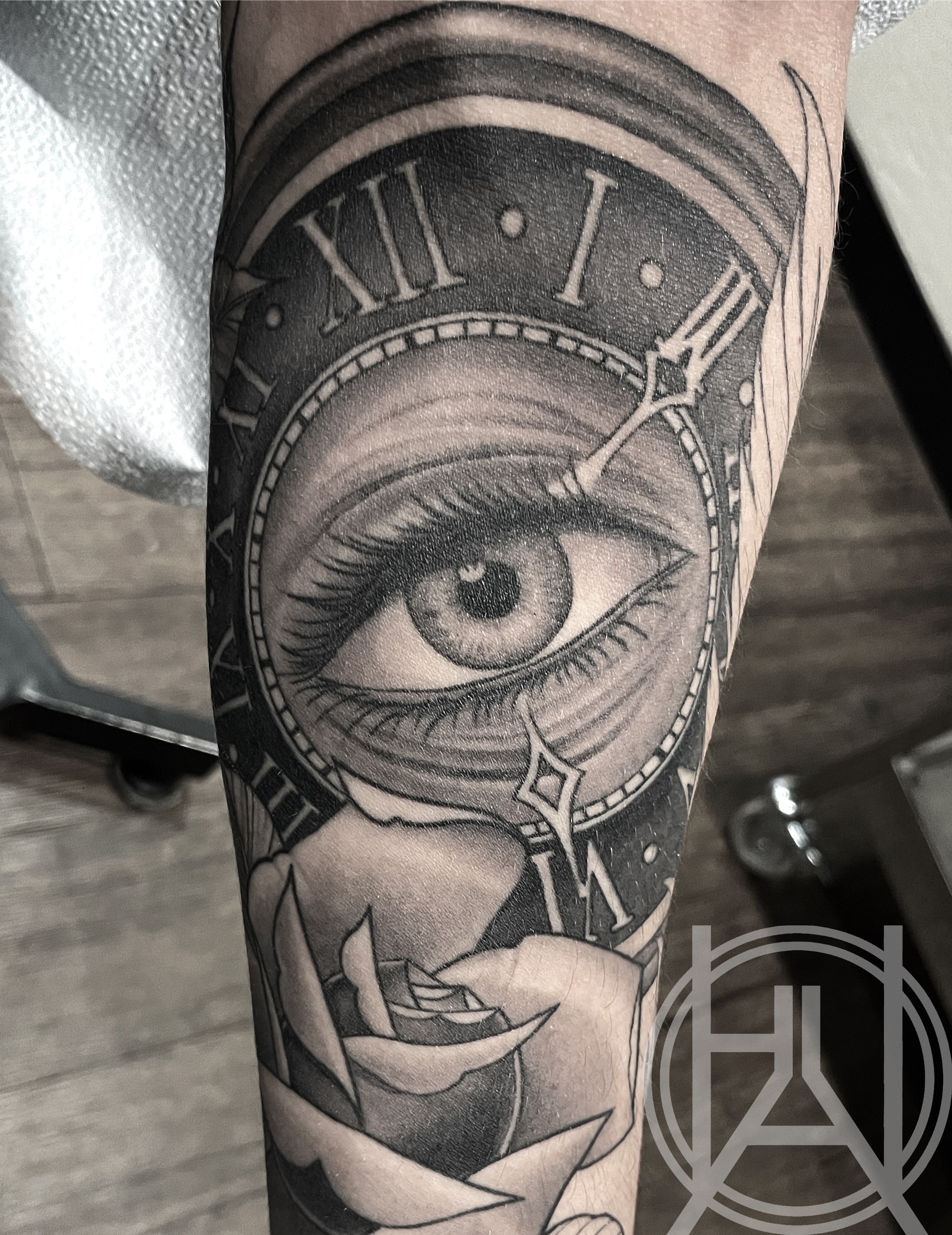 Eye inside clock face with rose — black and grey realism forearm
