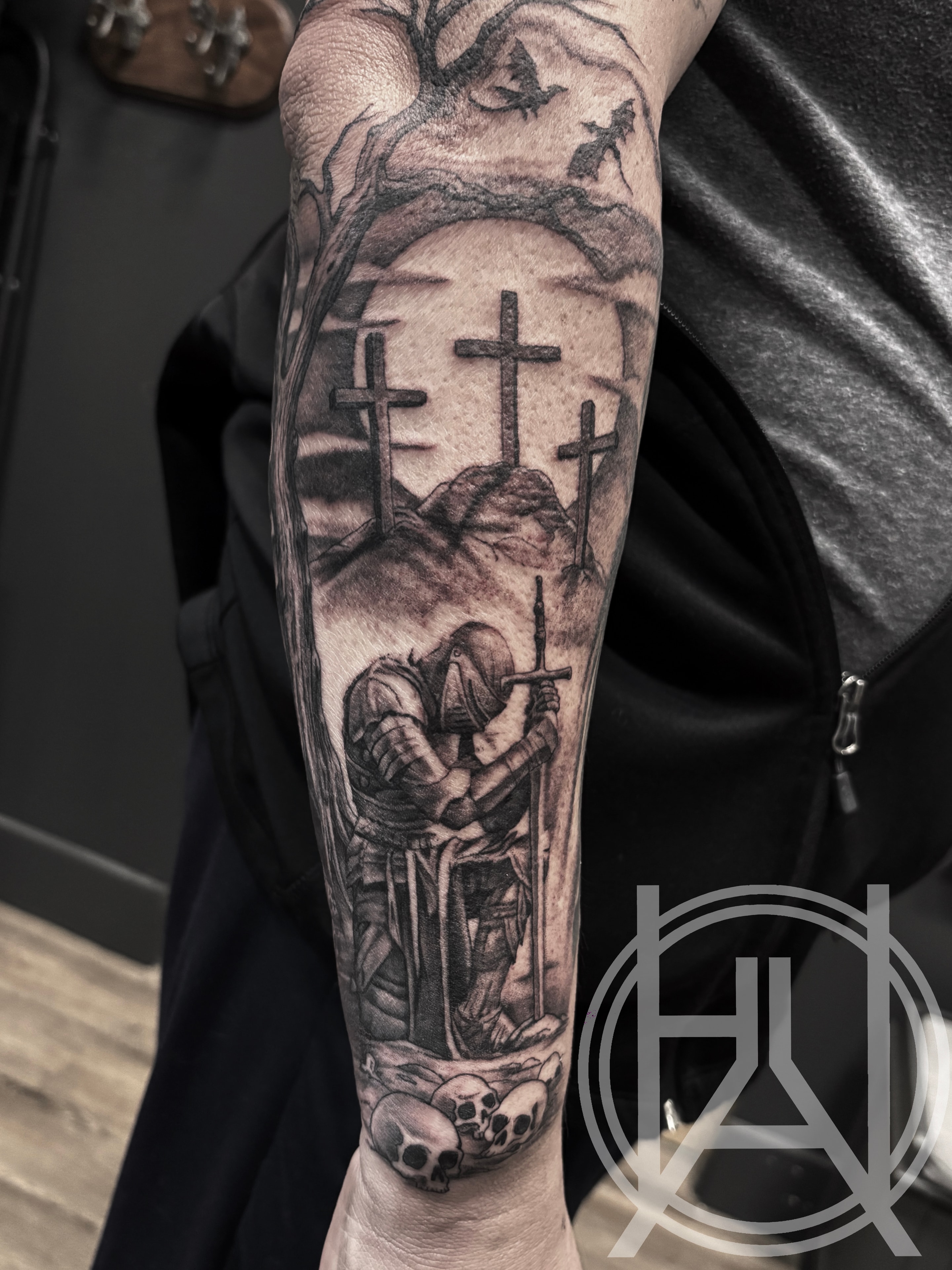 Kneeling knight at cemetery with crosses — black and grey forearm