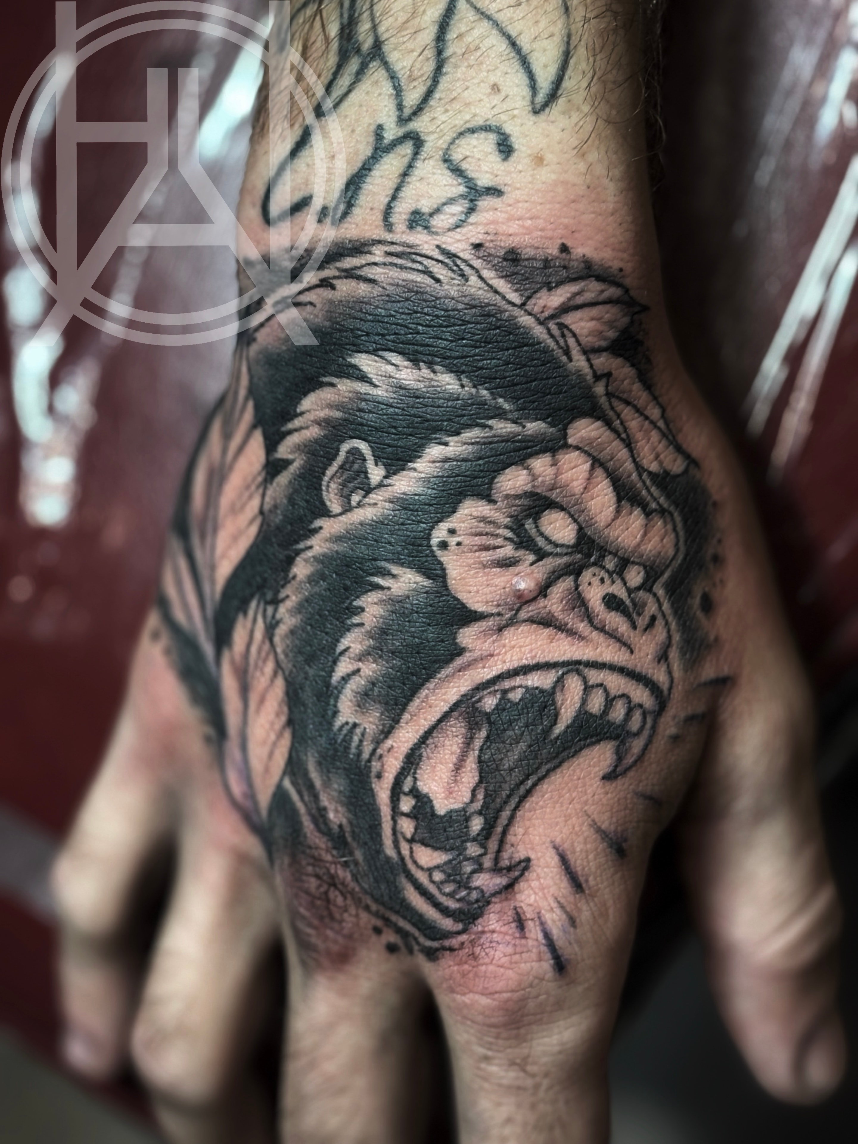Roaring gorilla hand tattoo — black and grey