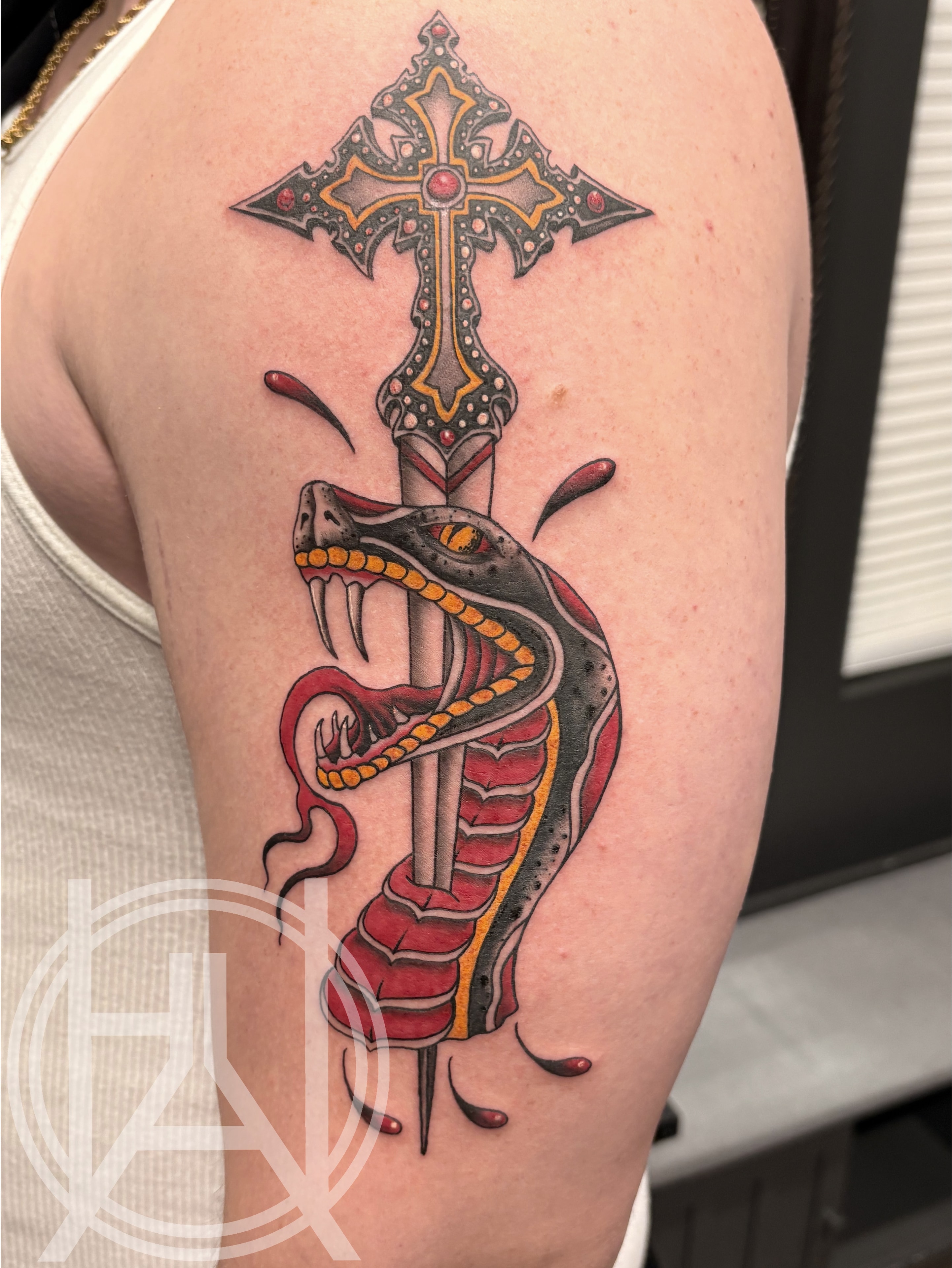 Snake wrapped around cross dagger — bold color traditional upper arm